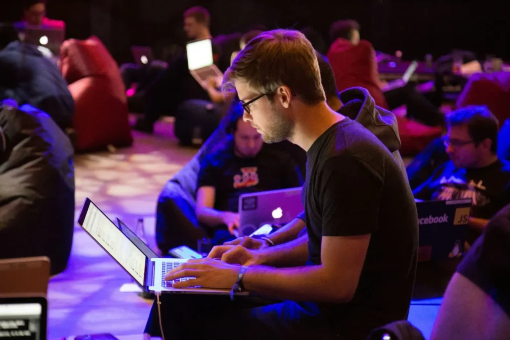 A man sitting with his laptop preparing to attend an SEO conference.